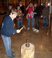 Zdjęcie z przeprowadzanej lekcji - uczń samodzielnie wybija pamiątkową monetę.